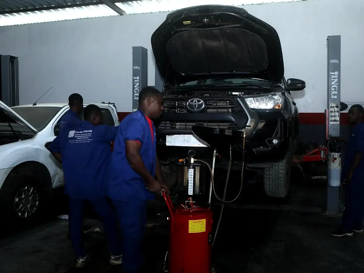 Vidange et entretien en cours sur un pick-up Toyota dans l'atelier Divine Ivoire Motors